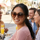 Woman wearing sunglasses smiling with friends at an outdoor cafe