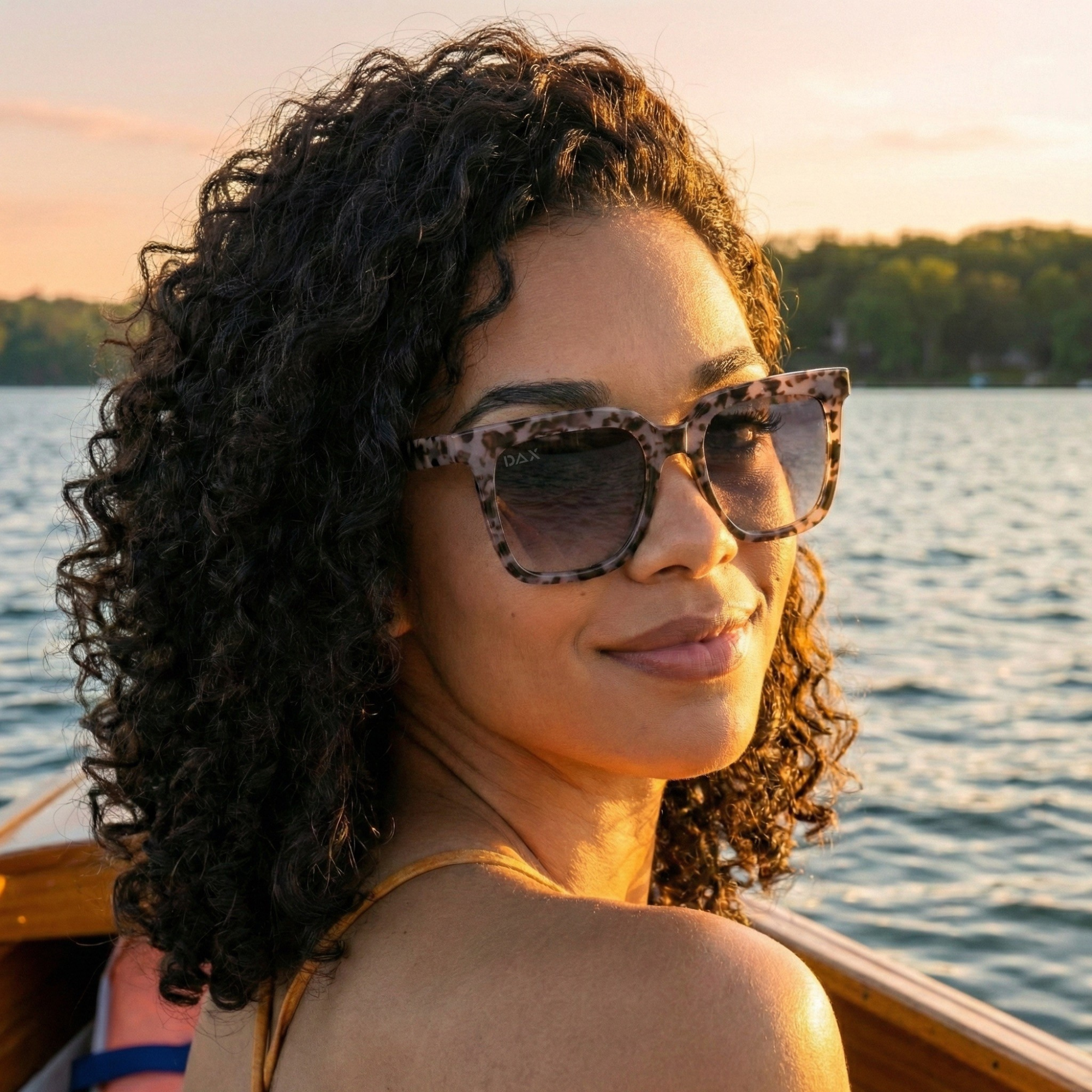 Woman wearing sunglasses on a boat with a scenic background
