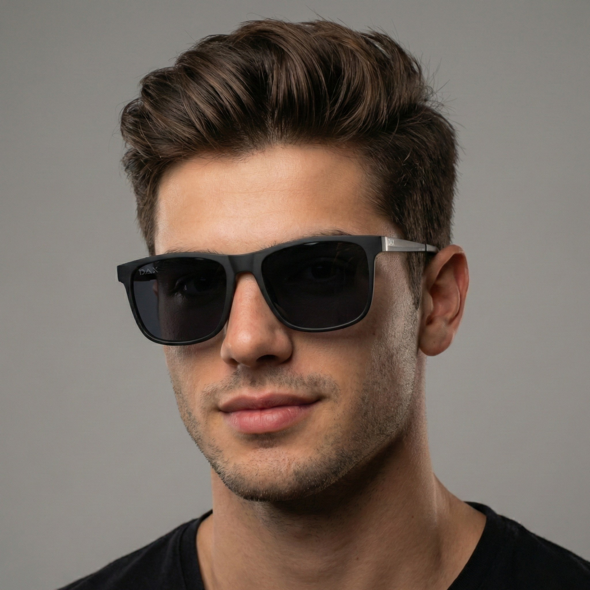 Man wearing dark sunglasses against a gray background