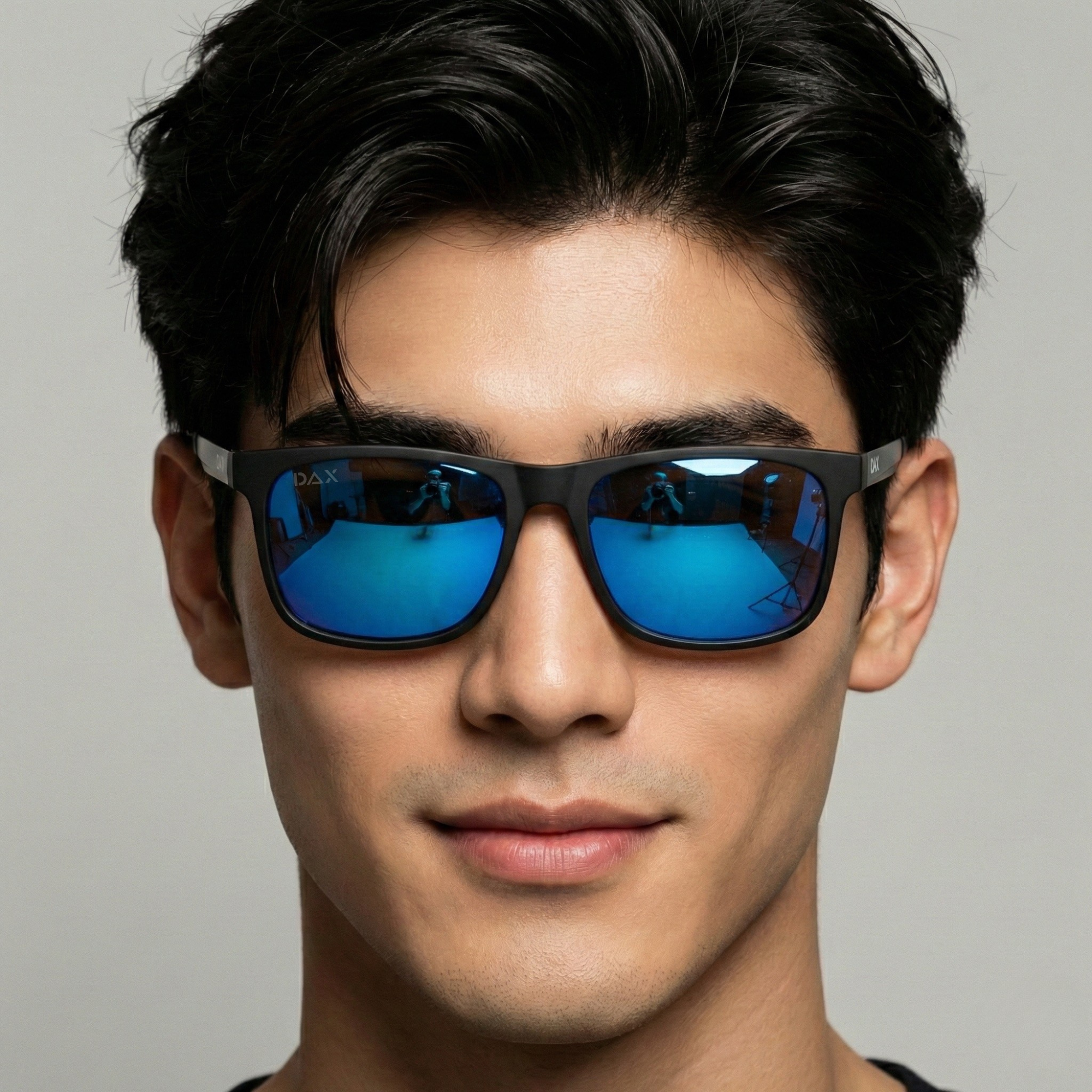 Man wearing blue reflective sunglasses against a neutral background