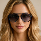 Woman wearing sunglasses with a neutral background