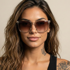 Woman wearing sunglasses with a neutral background