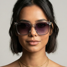 Woman wearing sunglasses with a neutral background