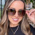 Woman wearing sunglasses with a blurred outdoor background