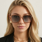 Woman wearing sunglasses with a neutral background