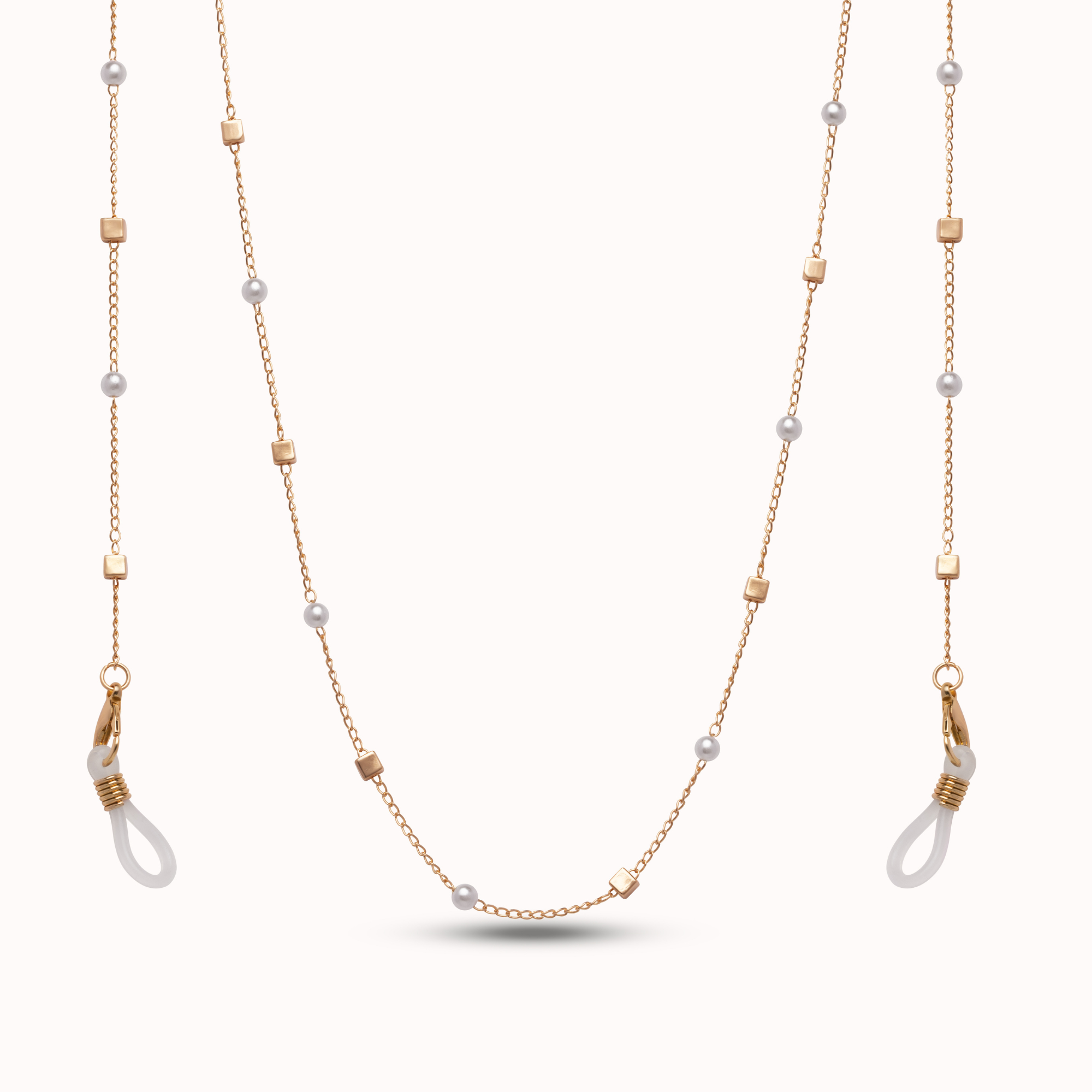 A delicate gold chain necklace and matching drop earrings featuring small white pearl-like beads and gold square spacer accents, displayed on a clean off-white background.