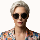 Woman wearing sunglasses with a floral-patterned shirt on a white background