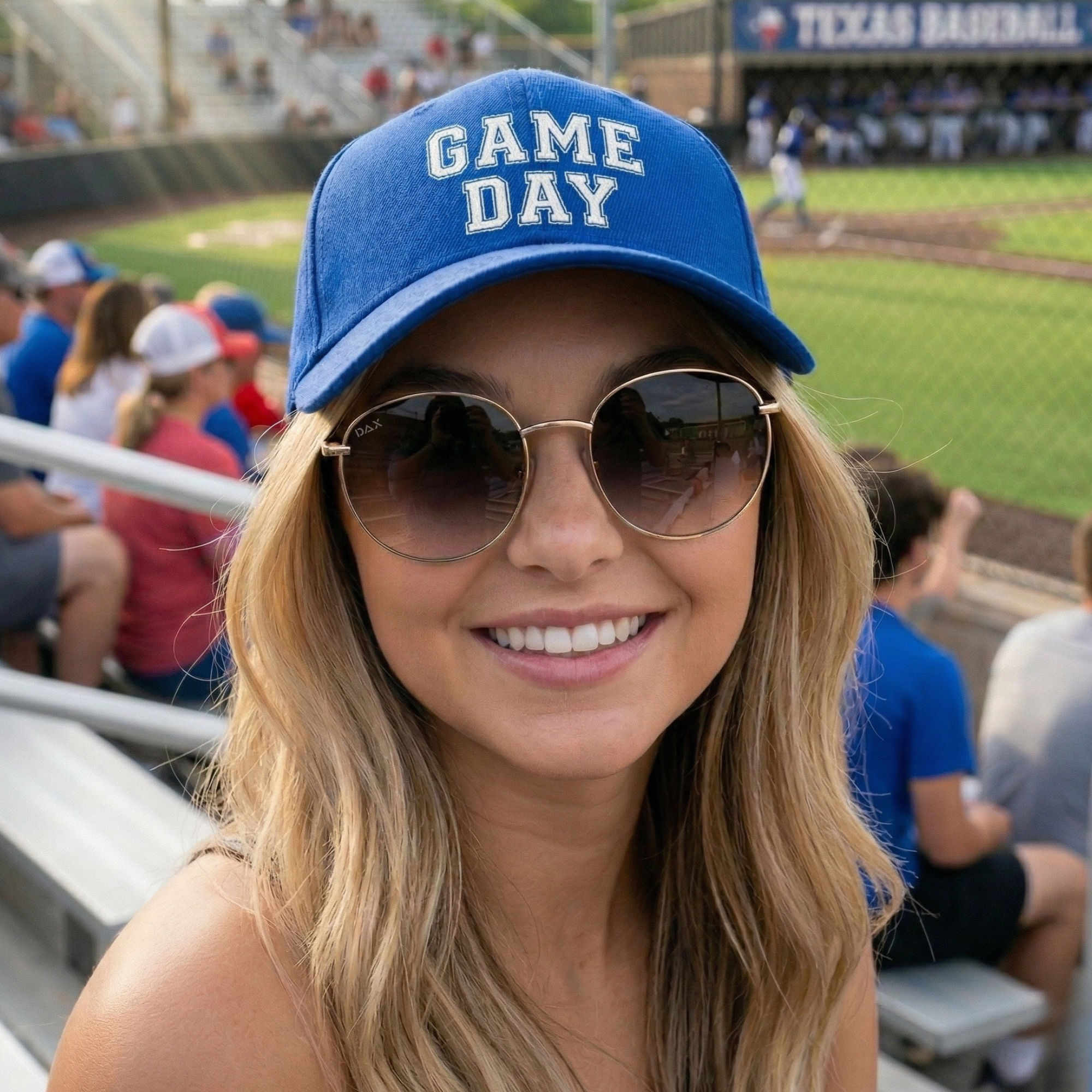 Woman wearing a 'Game Day' cap at a baseball game