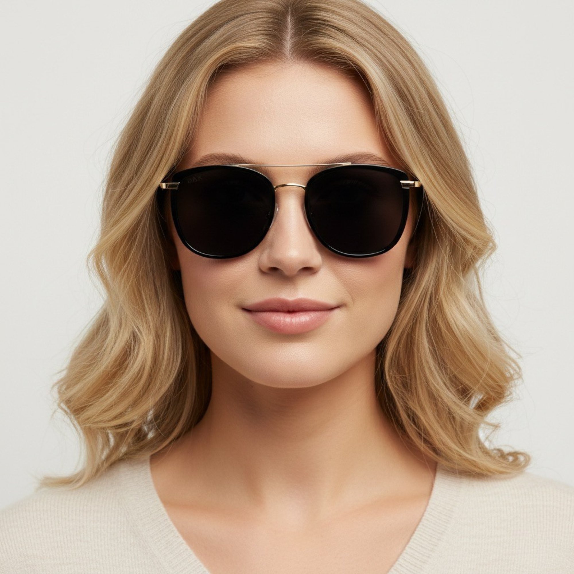 Woman wearing dark sunglasses with a plain background