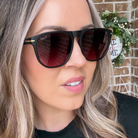 Person wearing black sunglasses with a blurred background