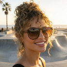 Woman wearing sunglasses with a skate park and palm trees in the background