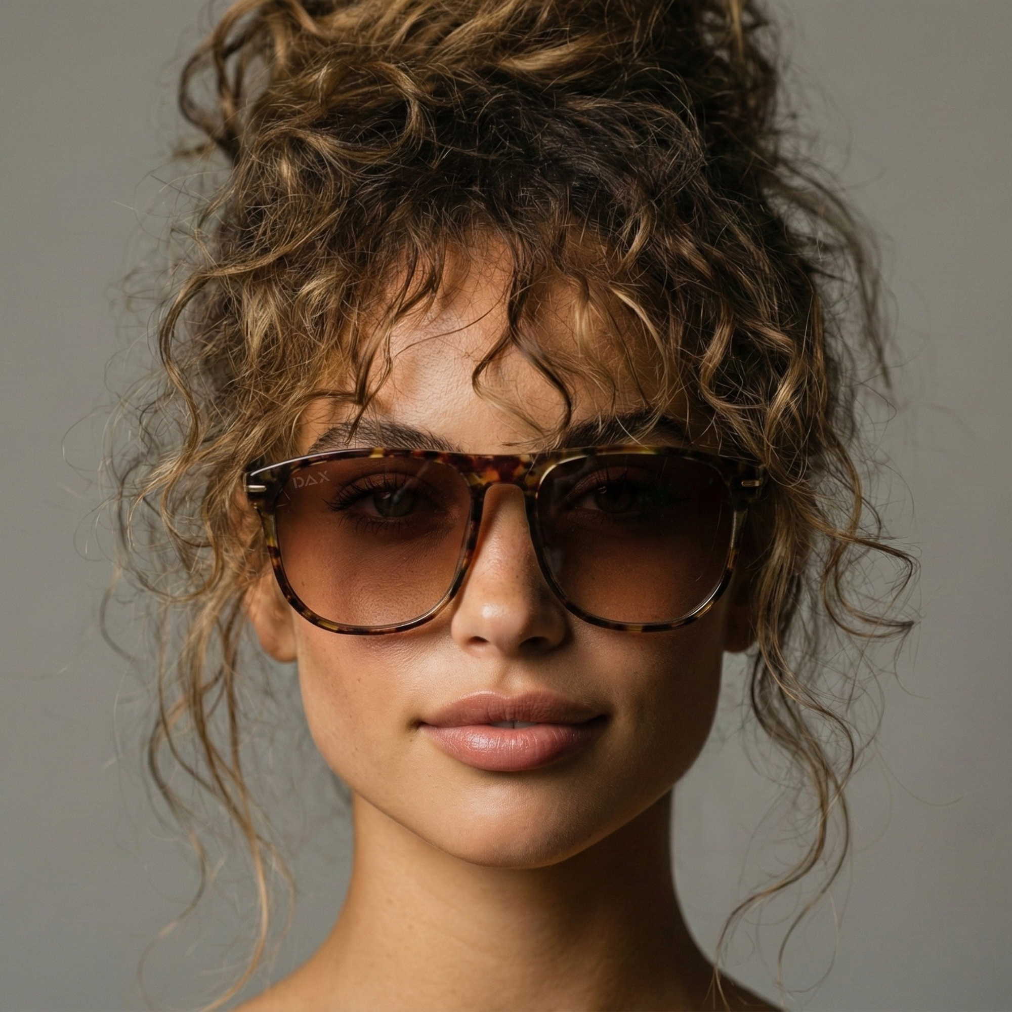 Woman wearing sunglasses with a neutral background