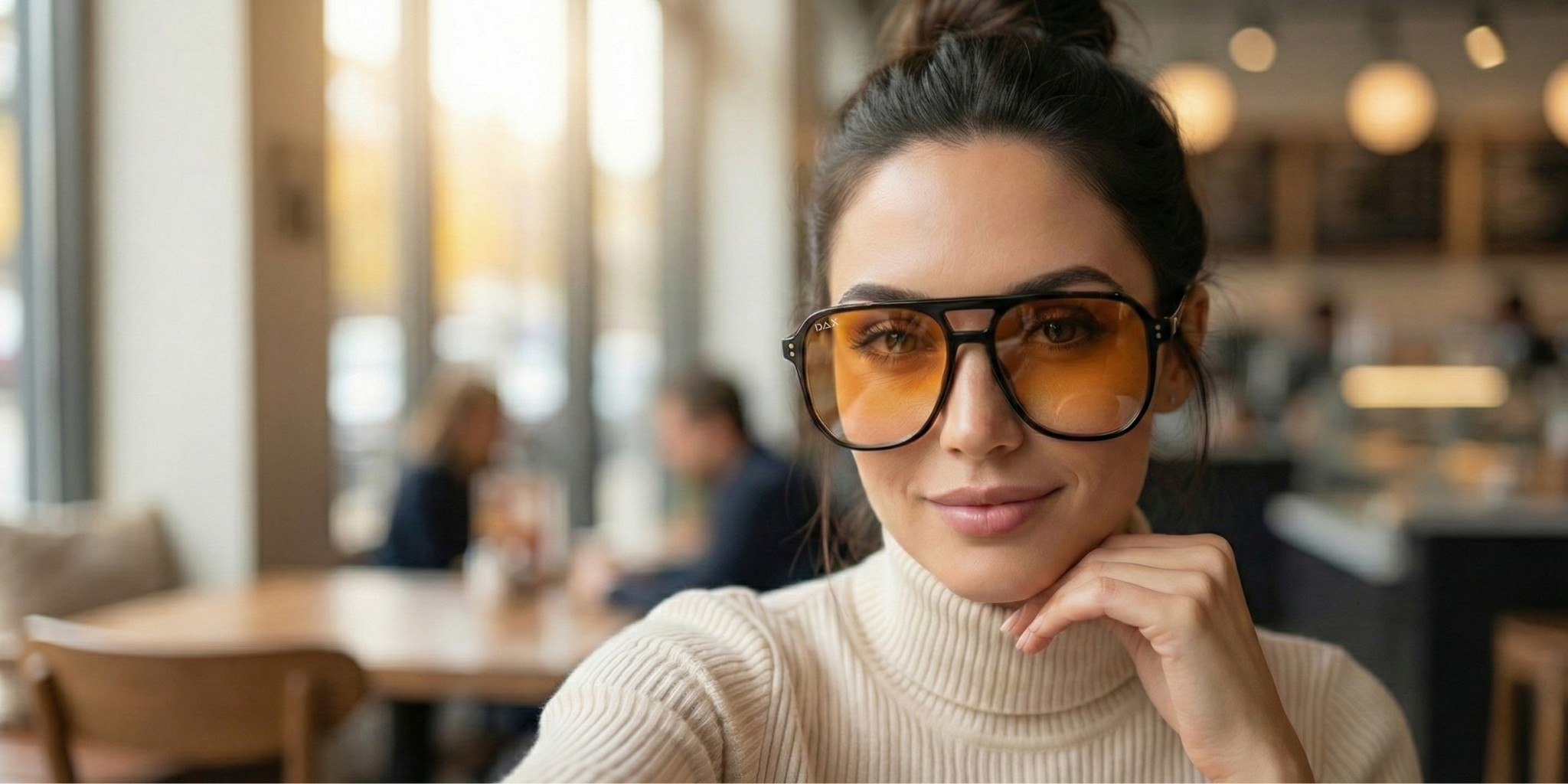 Woman wearing large sunglasses in a blurred indoor setting
