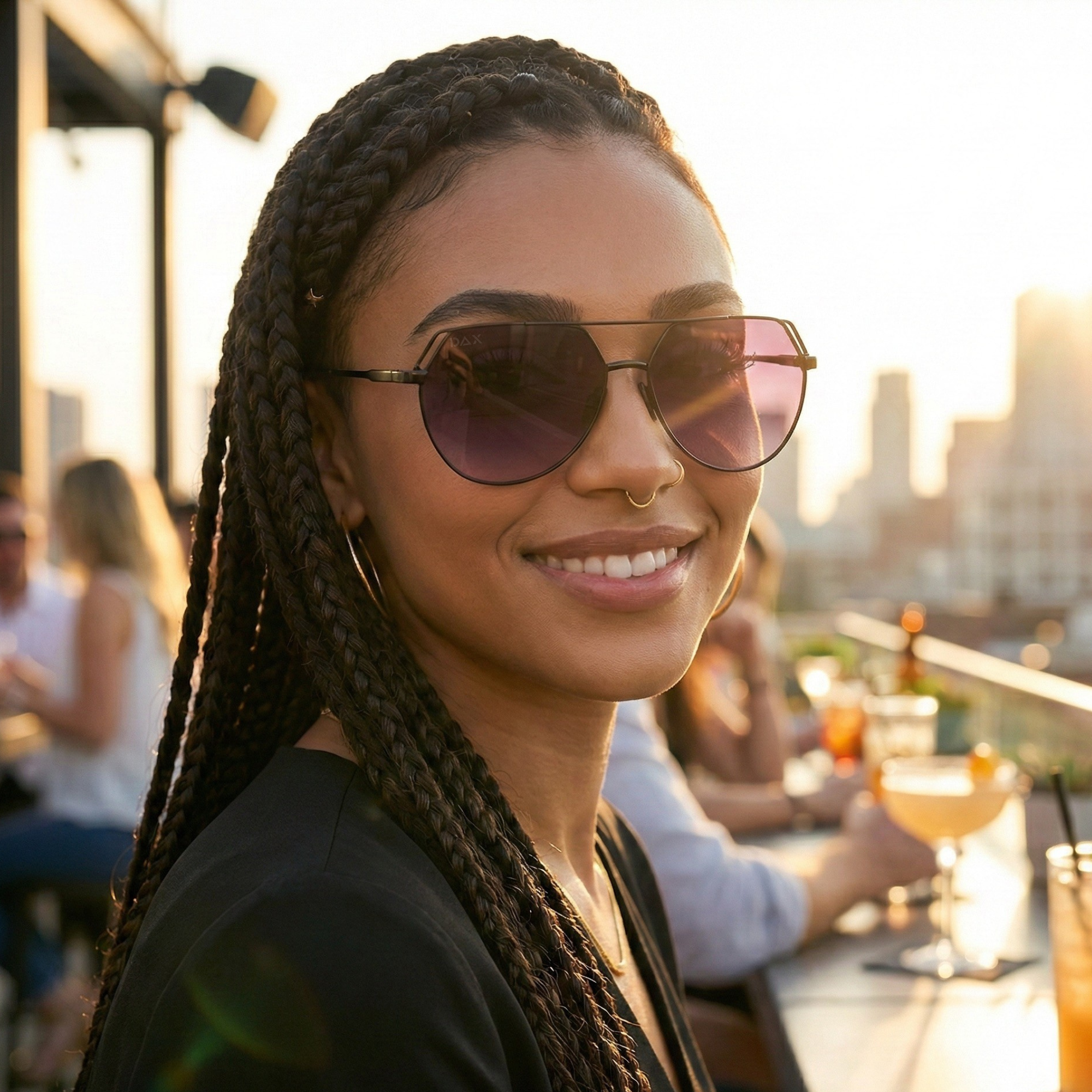 Woman wearing sunglasses with a cityscape in the background