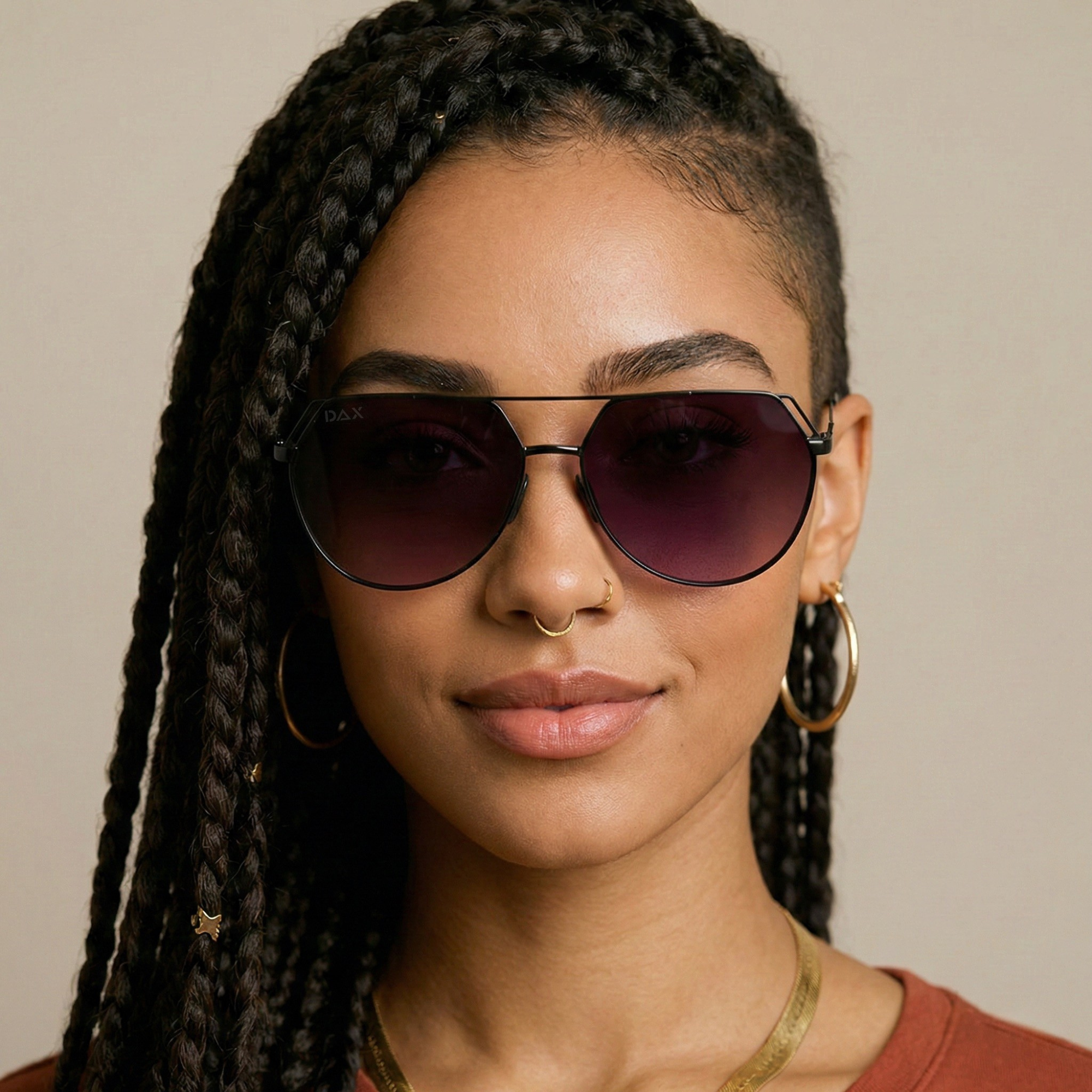 Woman wearing dark sunglasses with a neutral background