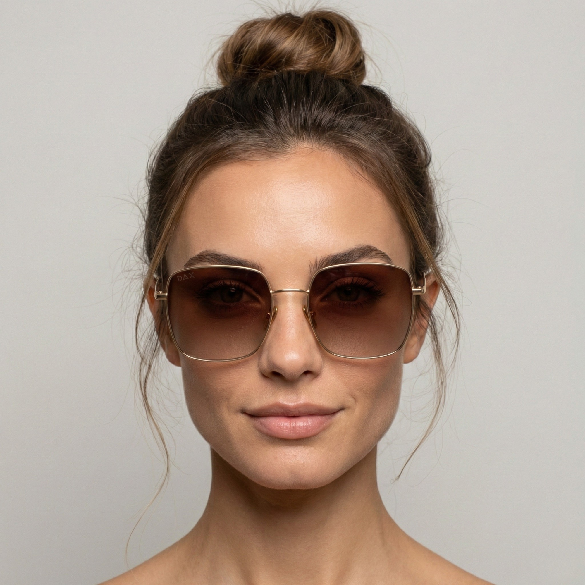 Woman wearing sunglasses with a neutral background