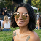 Woman wearing reflective sunglasses with a concert setting in the background