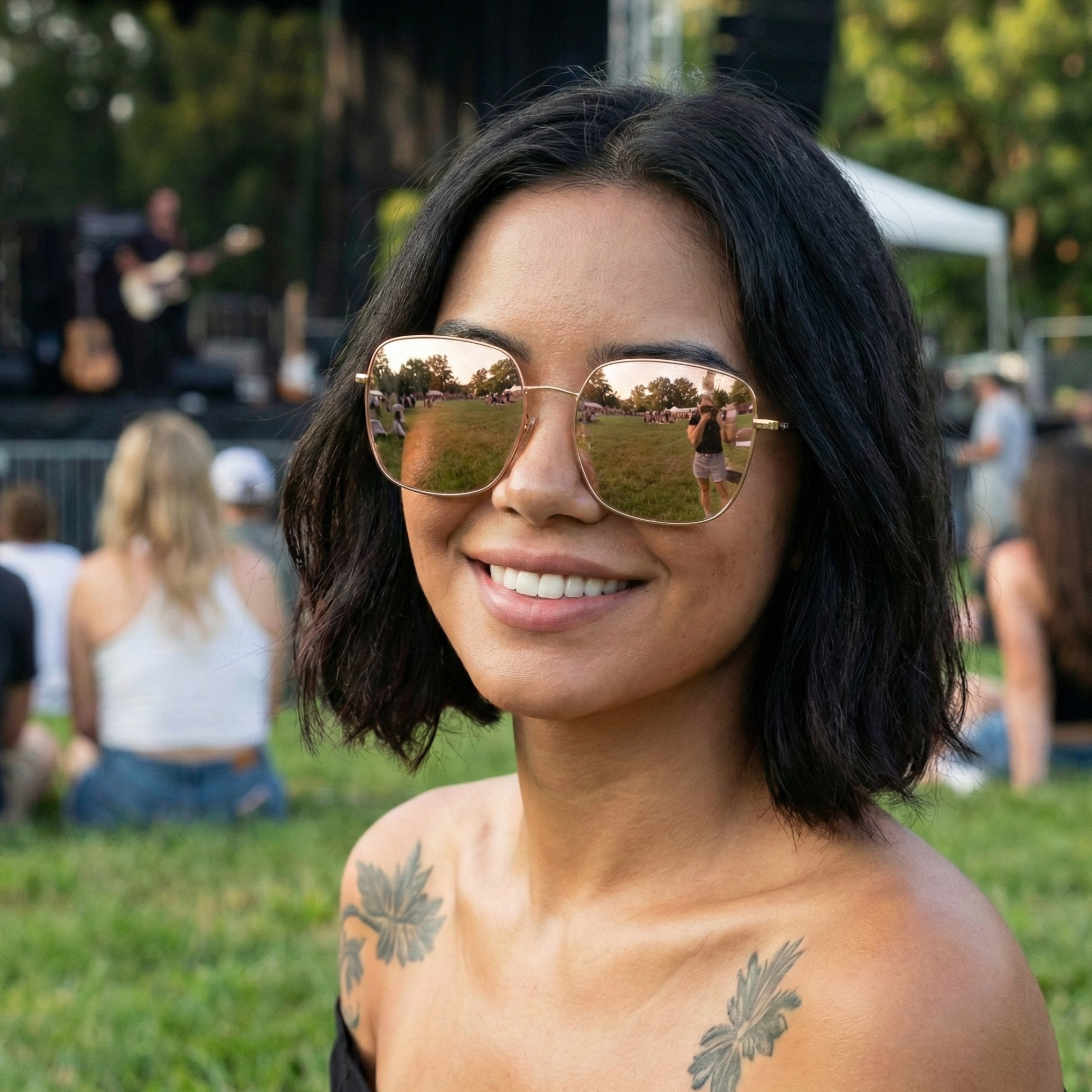 Woman wearing reflective sunglasses with a concert setting in the background
