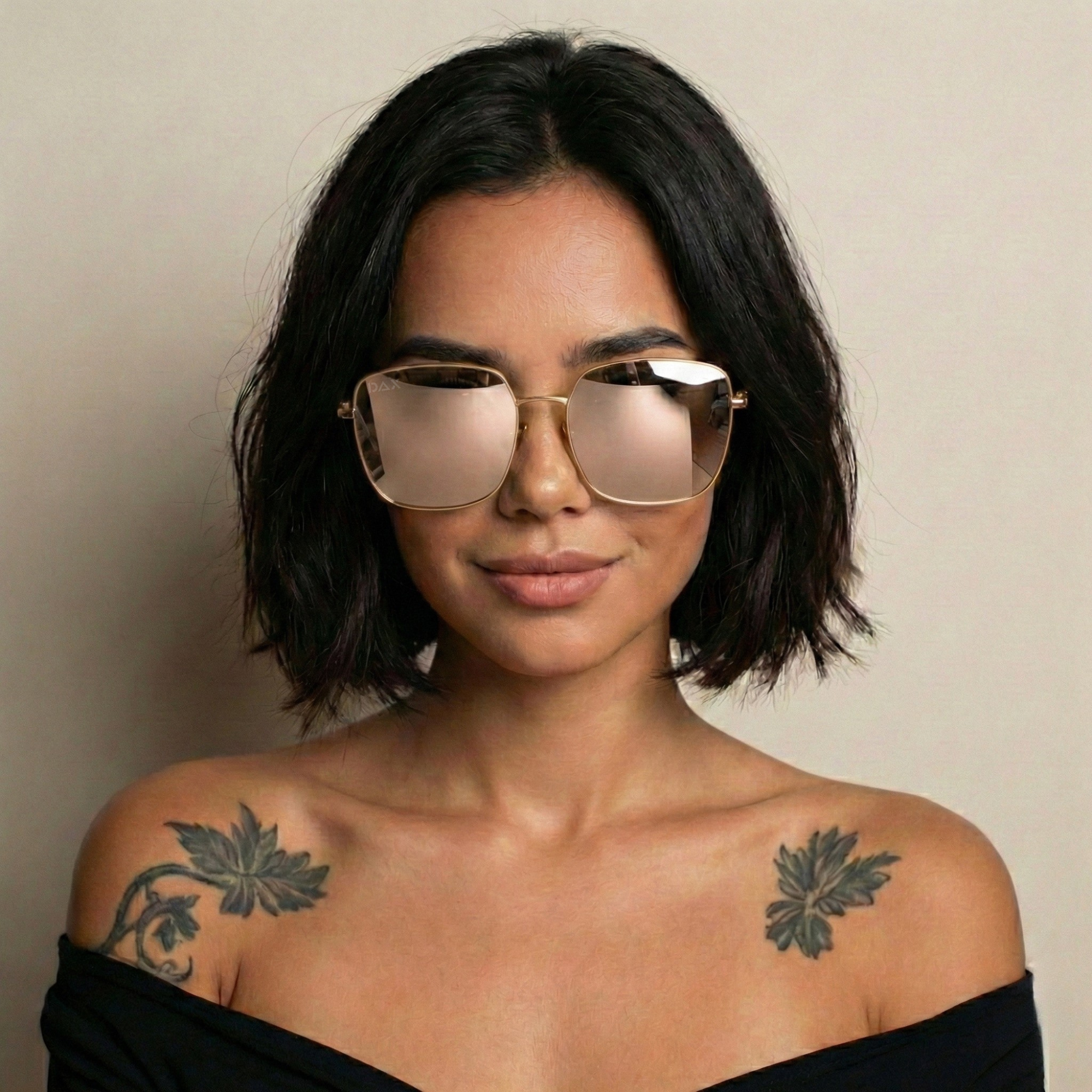 Woman wearing reflective sunglasses with a neutral background