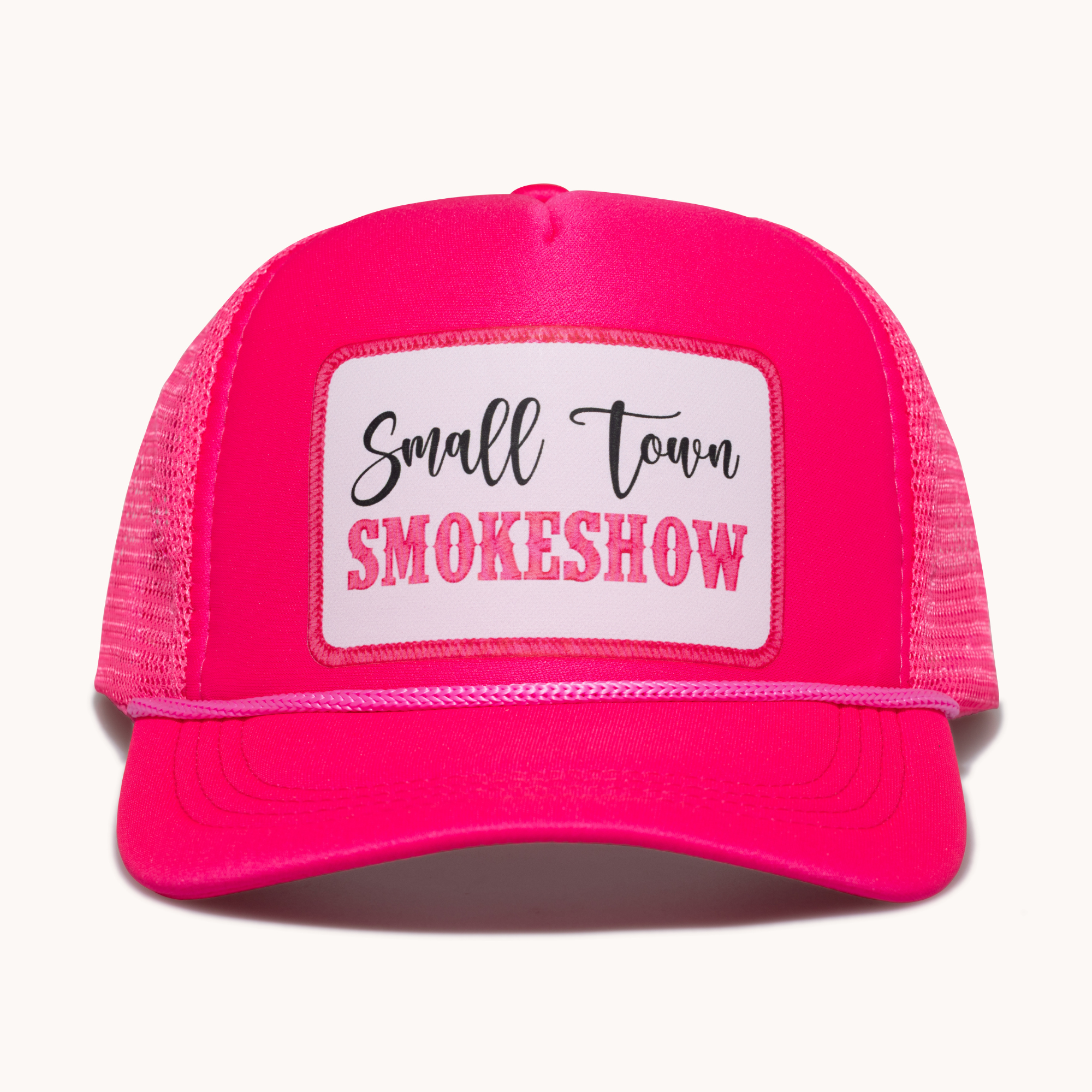 Pink trucker hat with 'Small Town Smokeshow' text on a white background